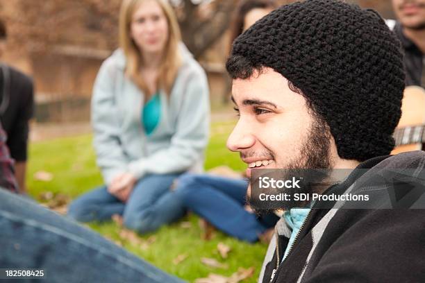 Young Man Smiling Lying Down With Friends At A Park Stock Photo - Download Image Now