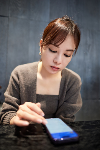 Selective focus on modern smartphone in woman hand. Female using cellphone, surfing and browsing internet, using online app, sending message, reading blog