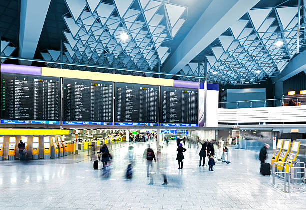 Modern Airport Airport Departure Board over the check-in counters  contains people stock pictures, royalty-free photos & images