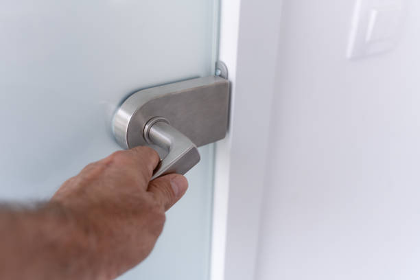 istock A hand on a glass door handle 1825099609