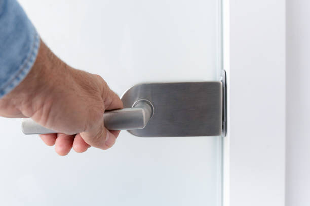 istock A hand on a glass door handle 1825099626
