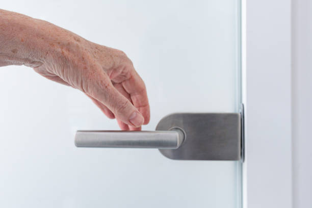 istock A hand on a glass door handle 1825099632