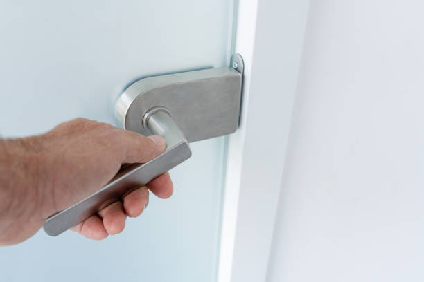 istock A hand on a glass door handle 1825099634