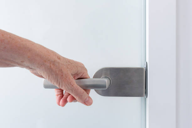 istock A hand on a glass door handle 1825099639