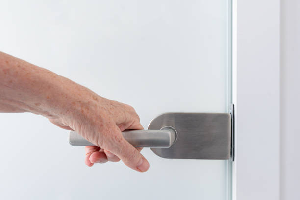 istock A hand on a glass door handle 1825099640