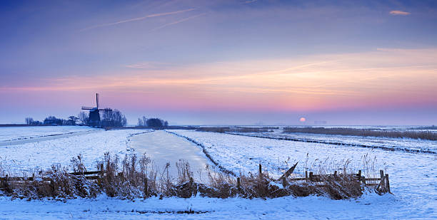 paysage avec moulin à vent néerlandais typique d'hiver au lever du soleil - polder windmill space landscape photos et images de collection