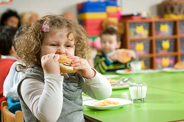 Hamburger and The Girl The girl is eating a hamburger. overweight child stock pictures, royalty-free photos & images