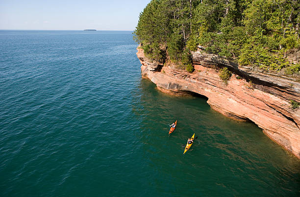 Birds eye view of kayaking couple in the ocean Couple sea kayaking on Lake Superior. bayfield county stock pictures, royalty-free photos & images