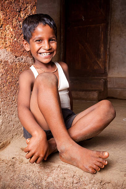 istock One Cheerful Rural Indian Boy Child Kid sitting Vertical 182512625