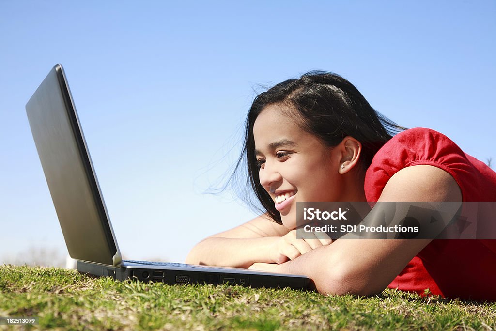 Junge Frau Blick auf Laptop auf dem Rasen - Lizenzfrei Aufregung Stock-Foto