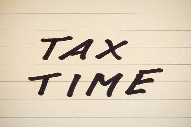 istock Tax time - written on yellow pad, copy space, close-up 182513631