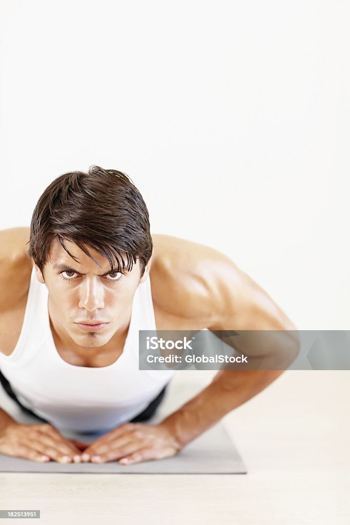 Fitness young man doing push ups at a gym Muscular young male doing push ups at a gym 20-24 Years Stock Photo