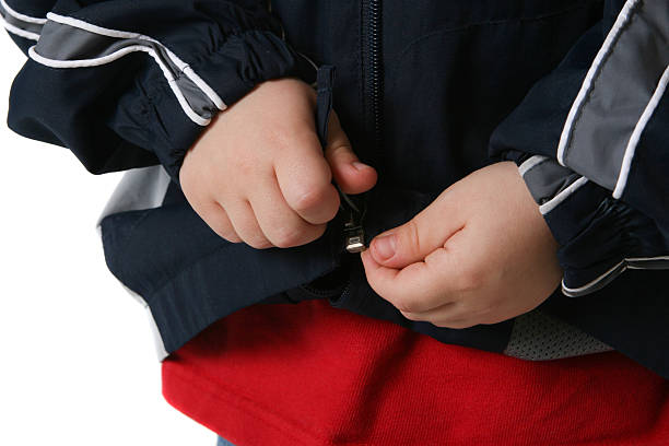 Child zips up coat stock photo