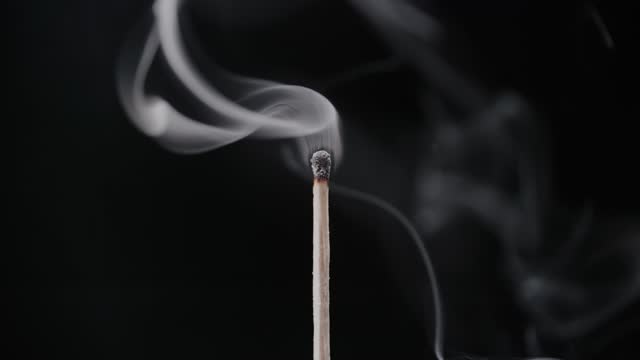 Smoke Swirling Around a Burned-Out Wooden Matchstick