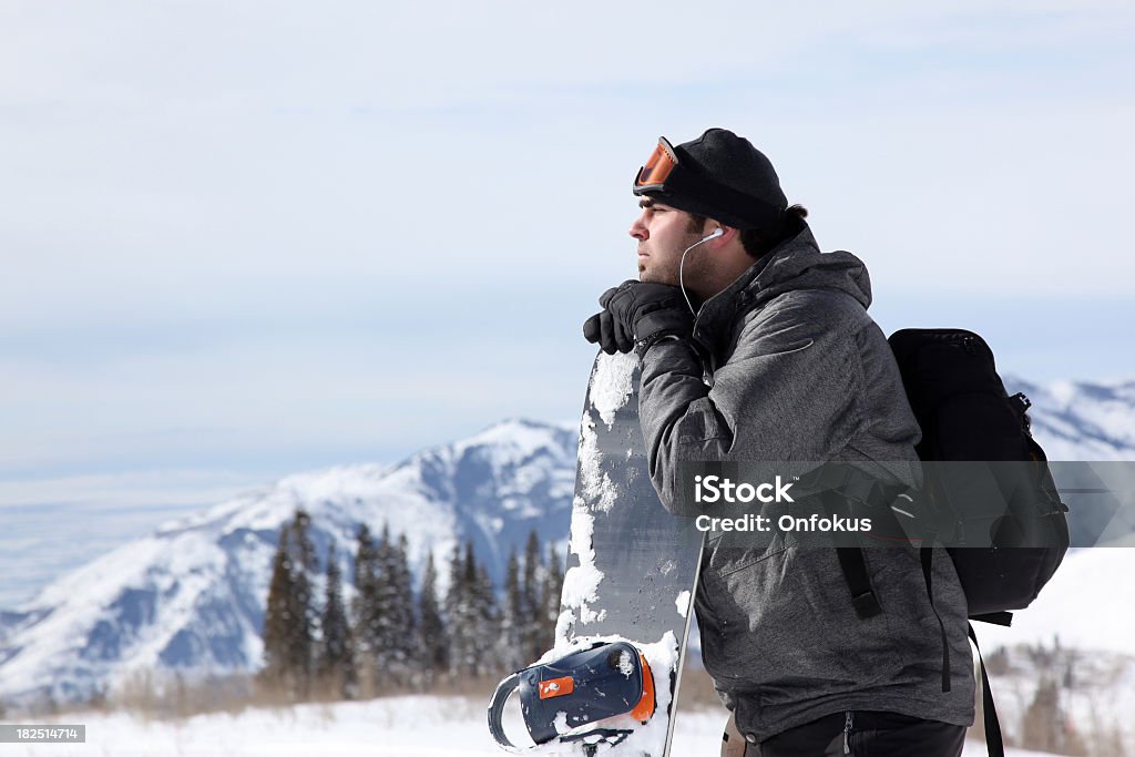 Homme snowboard se détendre et profiter de la musique avec Earpods - Photo de Ski libre de droits