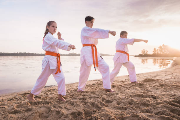 istock Children karate section training on beach sand near the river 1825149146
