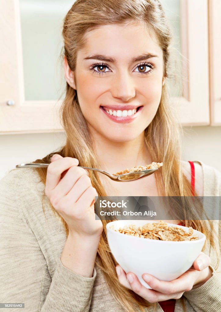 Teenager eating cereal Smiling teenager eating cereal 16-17 Years Stock Photo