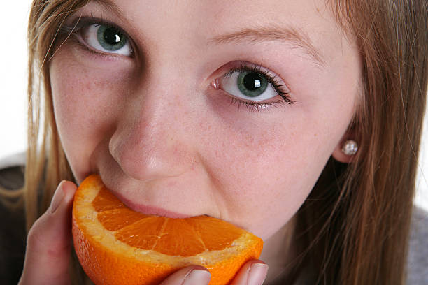 istock Girl Eating Orange 182515684