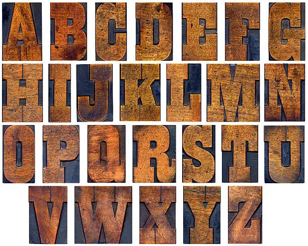 A Victorian woodblock alphabet with hand cut letters with color variation due to age and usage.