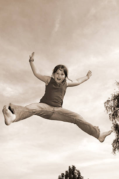 salto estrela - arms outstretched teenage girls jumping flying imagens e fotografias de stock