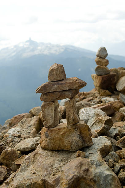 inukshuk A rock inukshuk at the top of a mountain inukshuk whistler cairn mountain stock pictures, royalty-free photos & images