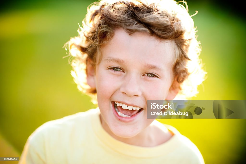 Heureux jeune garçon de rire en œuvre en soirée du soleil - Photo de 8-9 ans libre de droits