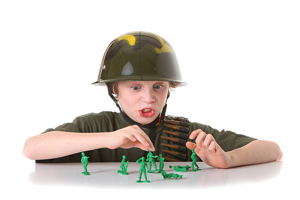 istock boy playing war with green army men 182517193