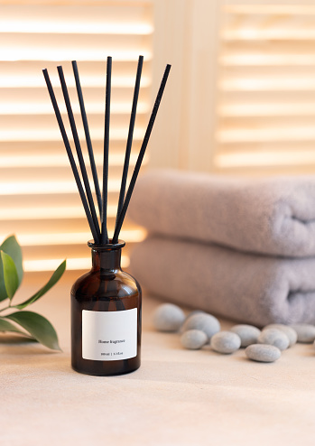 Aroma reed diffuser dark glass on table in bathroom or spa salon