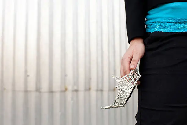 Photo of young woman holding a tiara at her waist