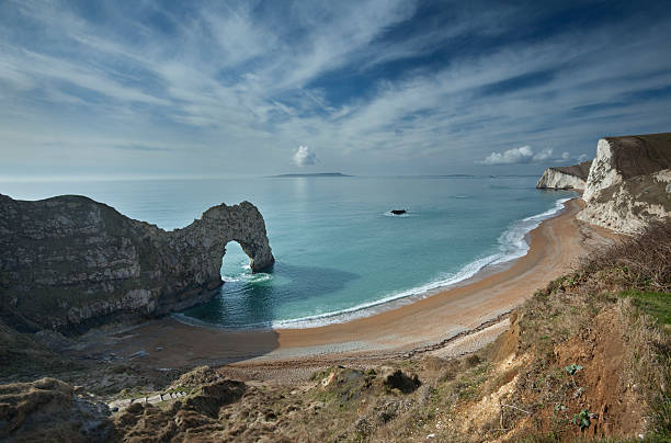 Aerial view of durdle door's dramatic white cliffs meeting the green sea in dorset, uk