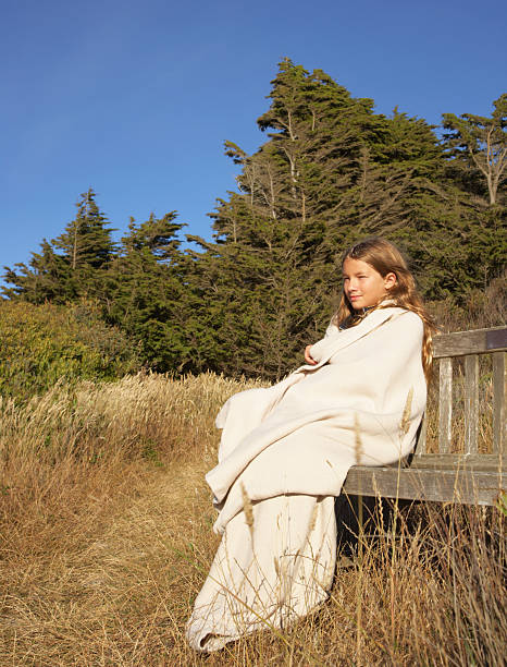 Girl Sitting on Bench in a Meadow stock photo