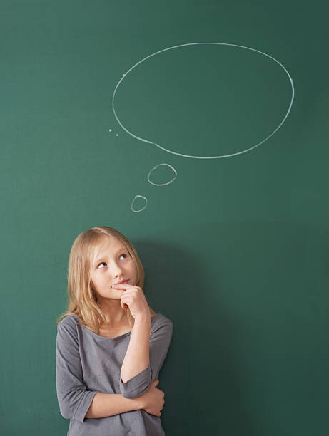 confondu la jeune fille avoir une bulle de pensée contre chalkboard - blackboard child thinking little girls photos et images de collection