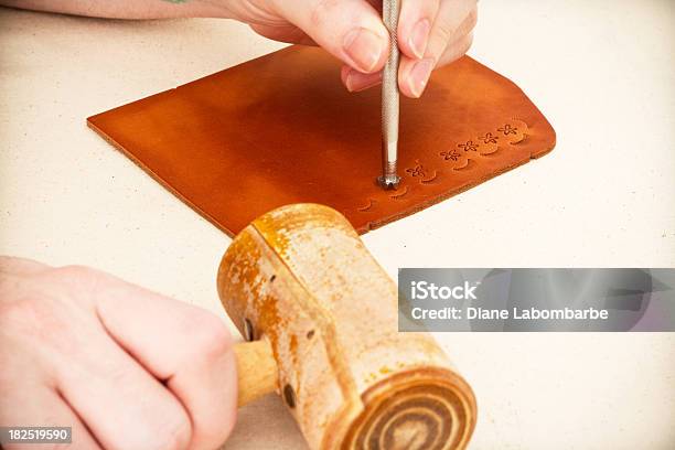 Hand Holding Stamping Tool Making Shapes In Piece Of Leather Stock Photo - Download Image Now