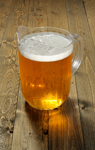Beer pitcher on a wooden background. More beer...