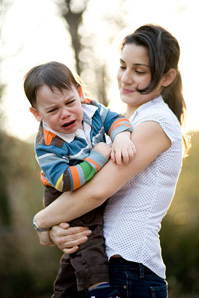 istock A child crying on his mothers arms 182519880