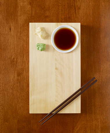 Sushi serving with soy sauce, wasabi and ginger on wooden table top