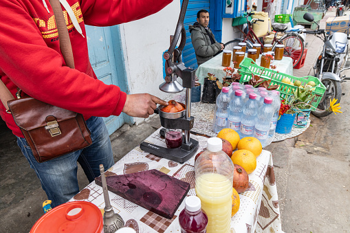 Testour, Beja, Tunisia. March 20, 2023. Man selling fresh squeezed pomegranate juice at the Testour souk.