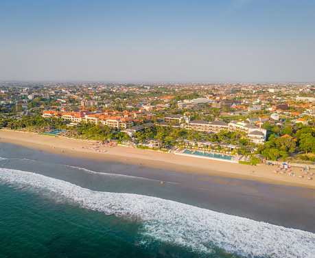 Aerial view of Seminyak beach coastline. The famous and luxury Kuta beach resort in southern Bali, Indonesia. Sunny day drone photo