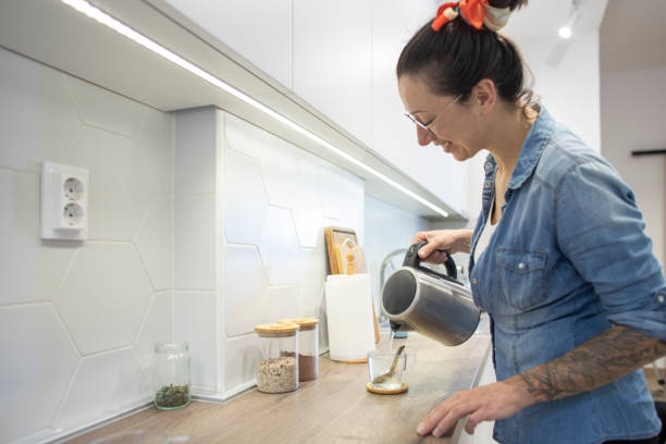 istock Young woman pouring water for tea into a thermos 1825290088
