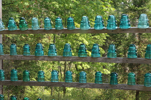Old glass insulators displayed in rows