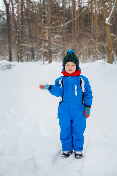 istock A cheerful child sculpts snowballs outdoors on a winter day. 1825308835
