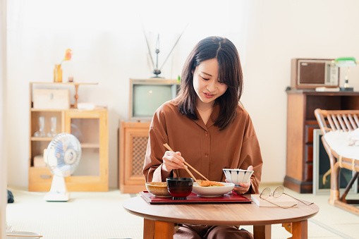 Young woman eating a meal in a Japanese-style room