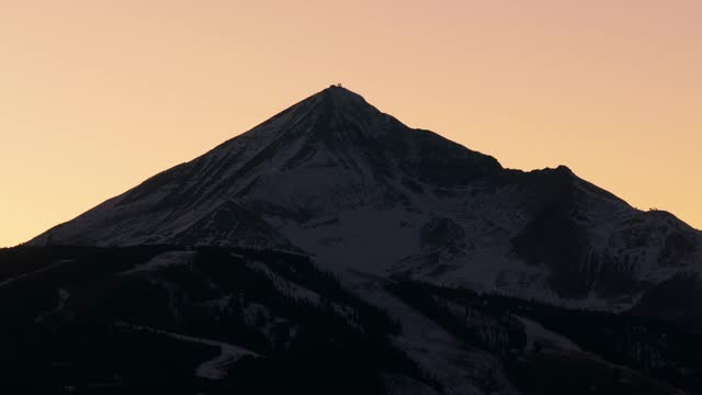 Cinematic drone shot of lone mountain peak at sunset in Montana