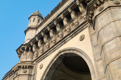 This image captures the imposing and majestic Gateway of India, an iconic landmark located on the waterfront in Mumbai. Built in the early 20th century to commemorate the visit of King George V and Queen Mary, this grand archway stands as a symbol of colonial history and Indian independence. The photograph showcases the Gateway's intricate Indo-Saracenic architecture, with its large arches and detailed reliefs. The scene is set against the backdrop of the Arabian Sea, adding to the monument's grandeur and its significance as a coastal landmark.