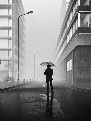 Black and white 3D render of a lonely man with an umbrella standing on deserted foggy city street