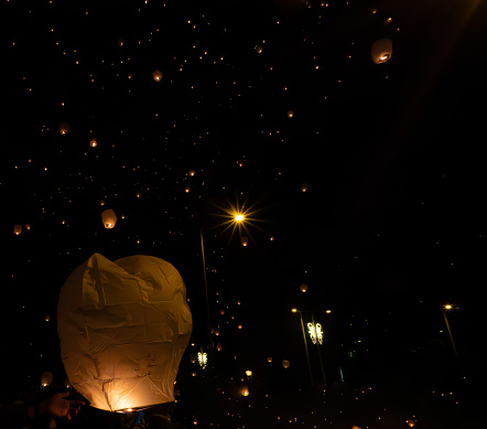 hand throws lantern to the sky, lanterns with Christmas decorations. In popular festival in Pamplona Navarra, twinned with Baione france.