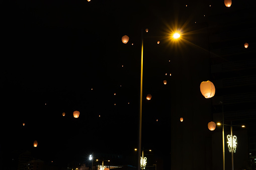 Chinese lanterns released into the air light up the sky and the Christmas decorations of Pamplona Spain.