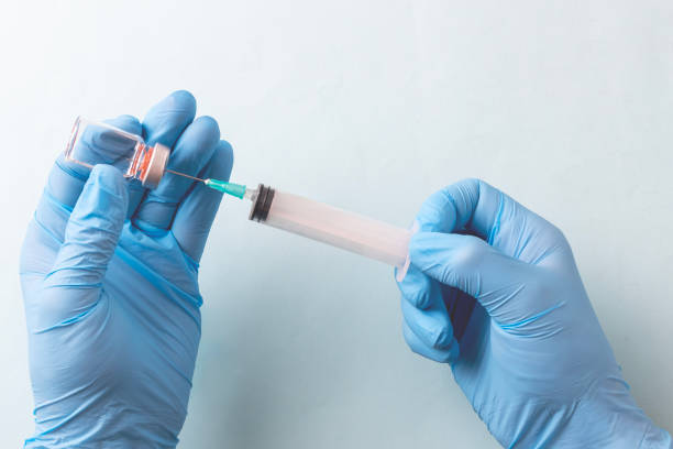 istock Doctor is holding a syringe , isolated on blue background 1825384746