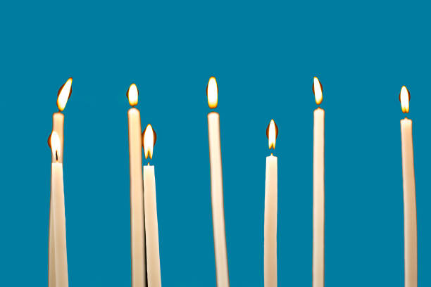Group of Lit Church Candles, blue background.