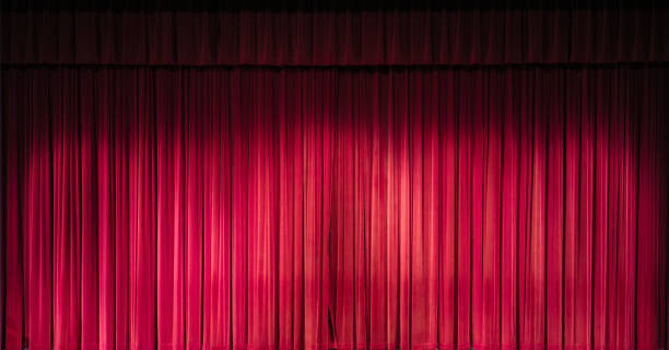istock Empty theater stage with red velvet curtains 1825403526